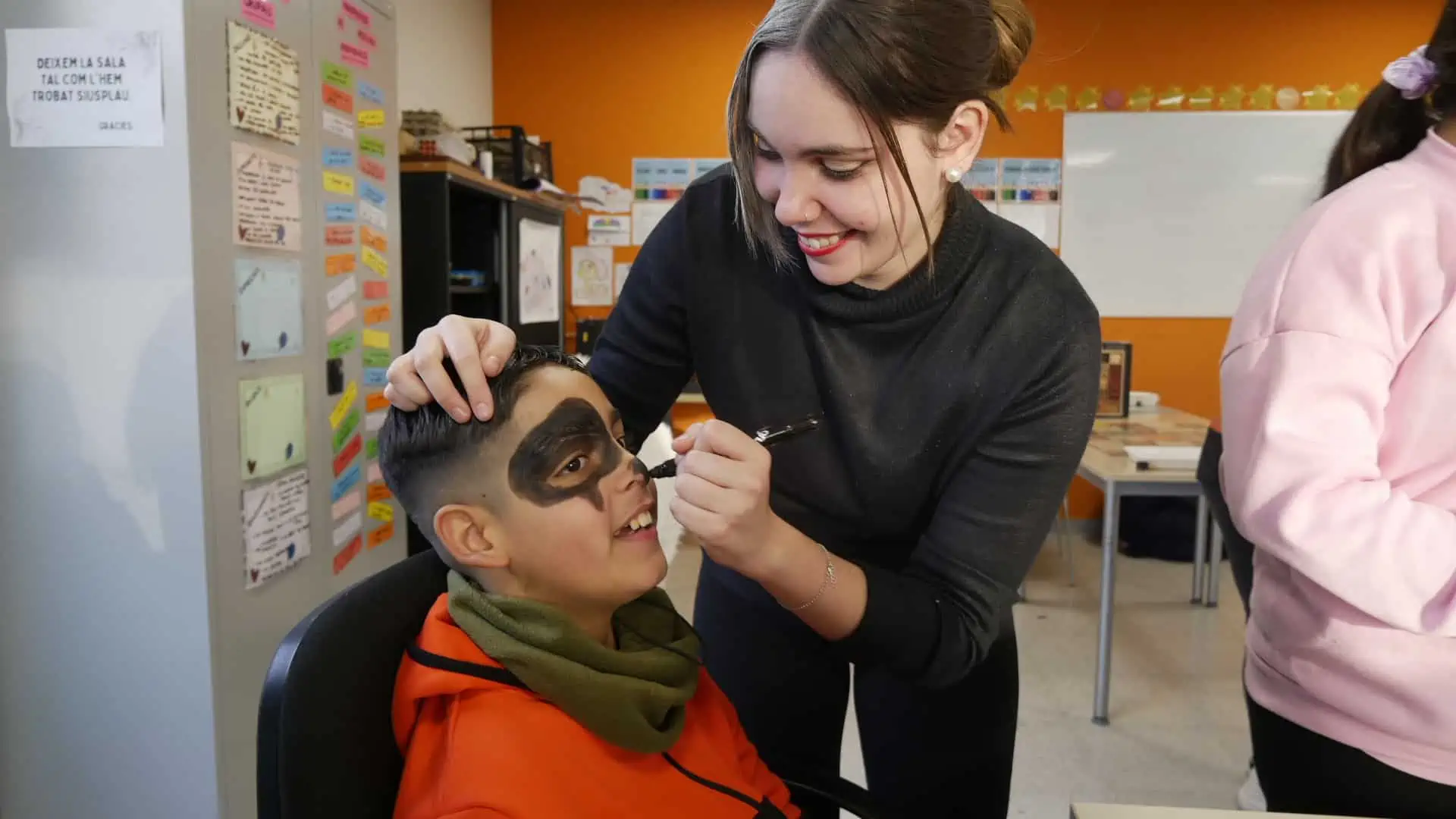 Noia maquilla a un nen pel Carnestoltes de La Mina.
