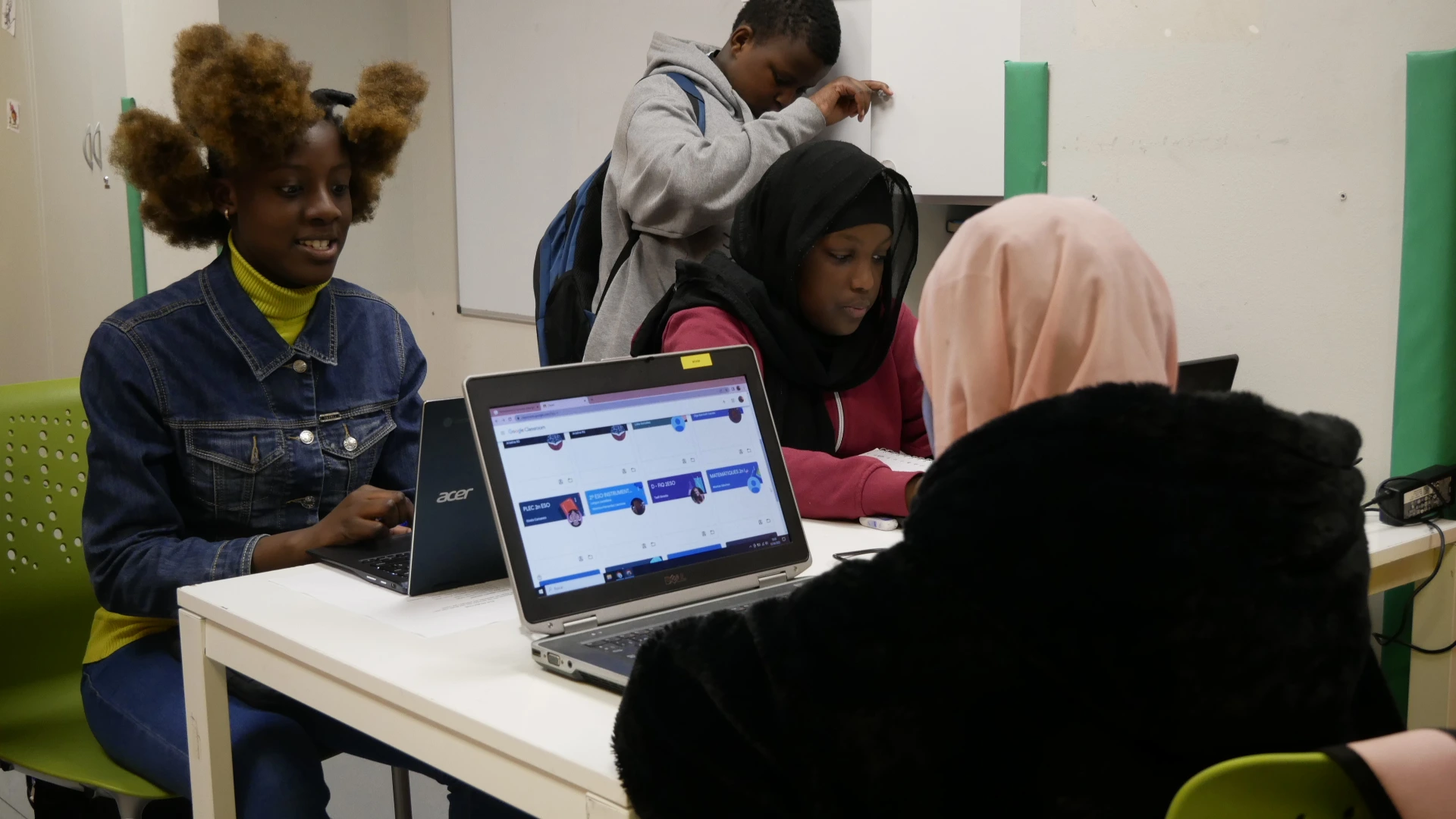 3 noies fent deures amb ordinadors portàtils, i noi aquesta amb elles. portada Impuls