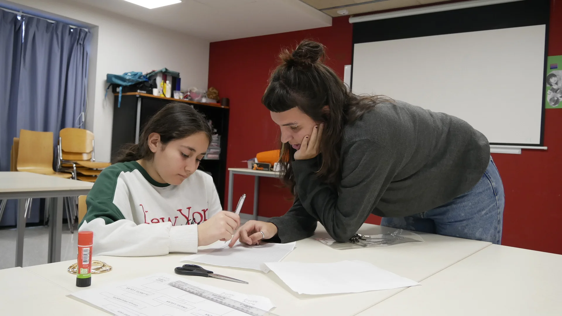 Una educadora ajuda a una adolescent amb els deures. Centre Socioeducatiu "El Racó" per a adolescents