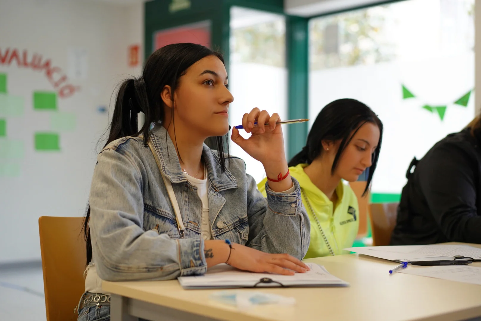 Una noia fent el reforç acadèmic en una postura i cara pensativa.