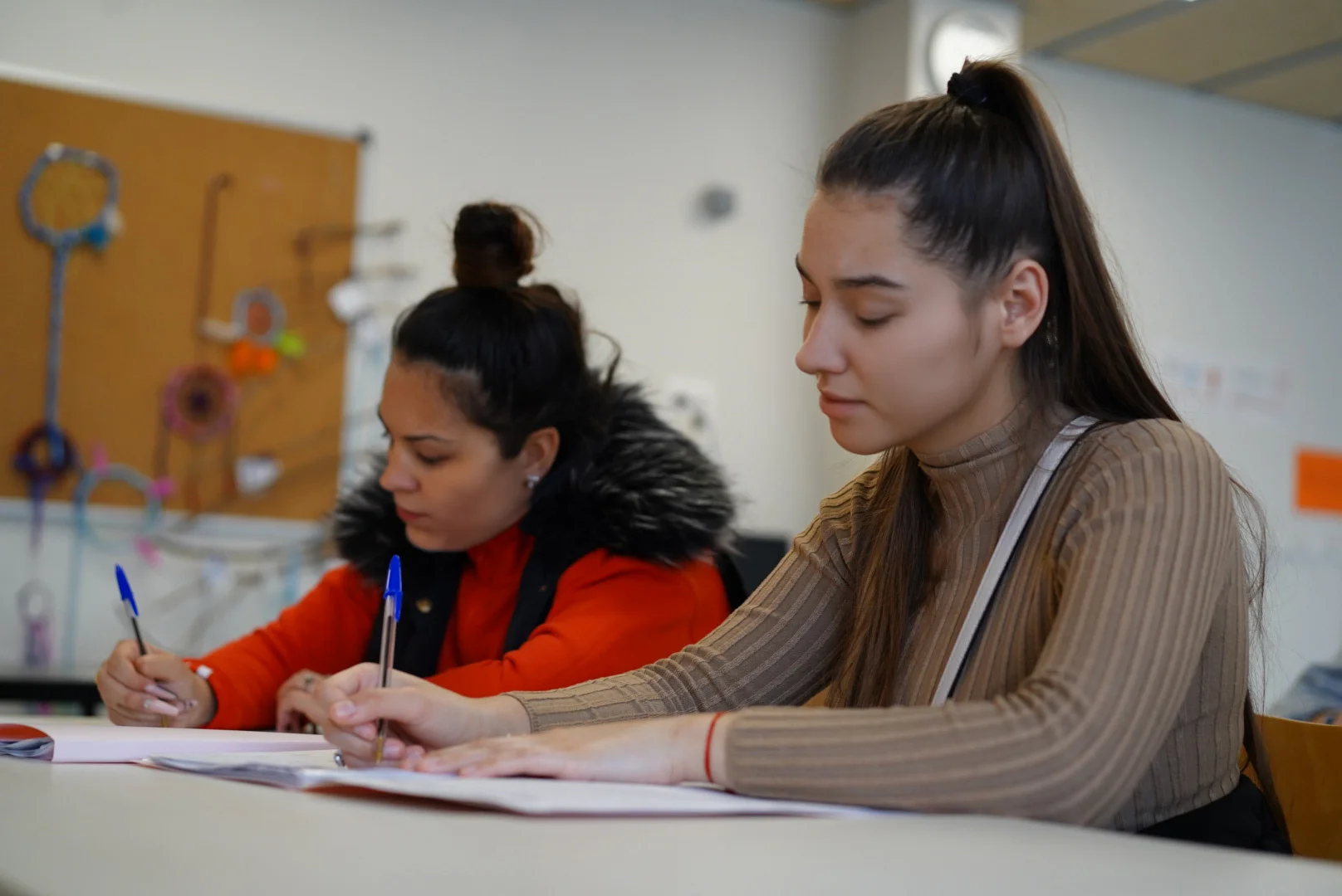 2 noies escrivint sobre, l'Abordatge d’absentisme a La Mina - Sant Adrià de Besòs