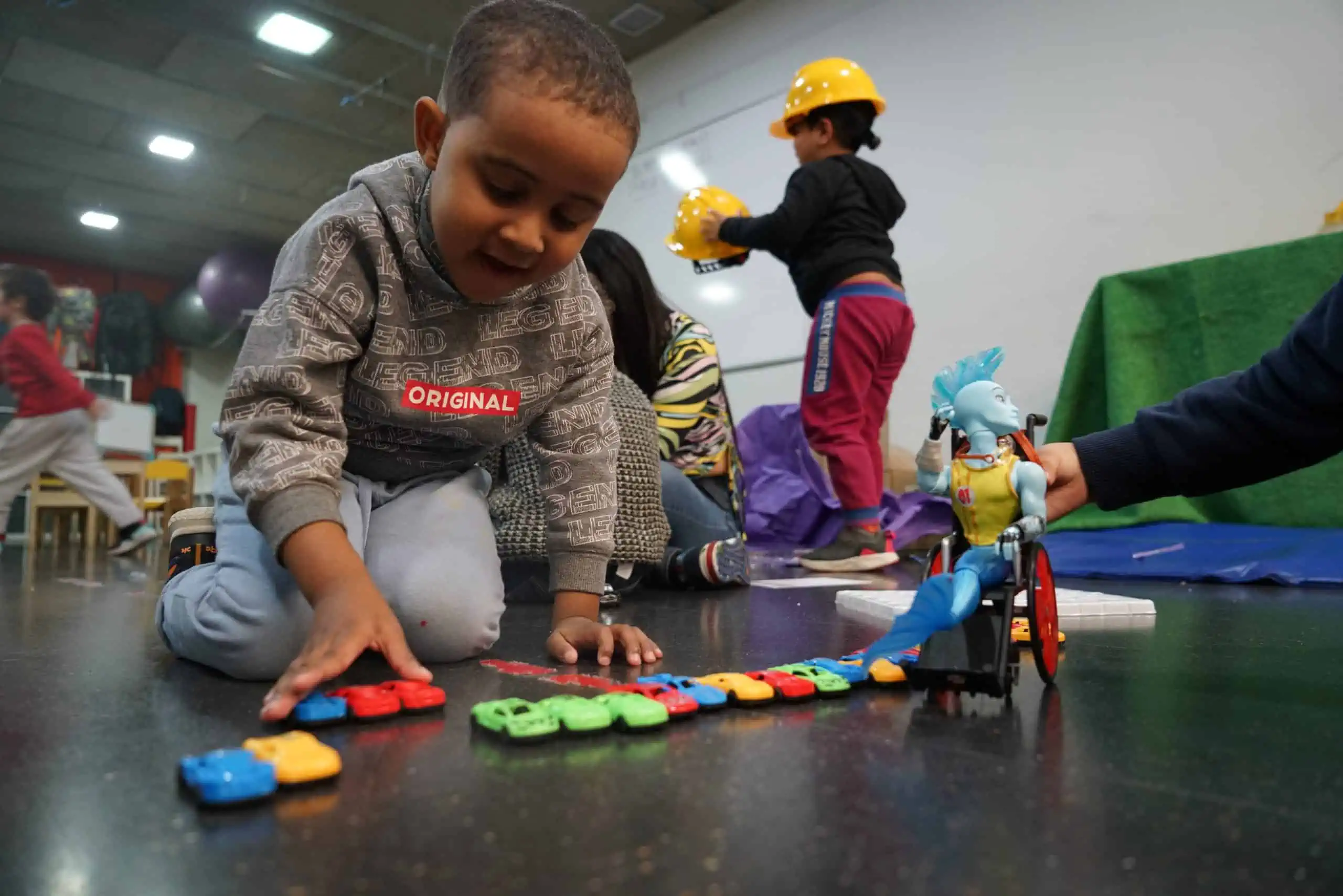 Nen petit juga amb cotxes de joguina.