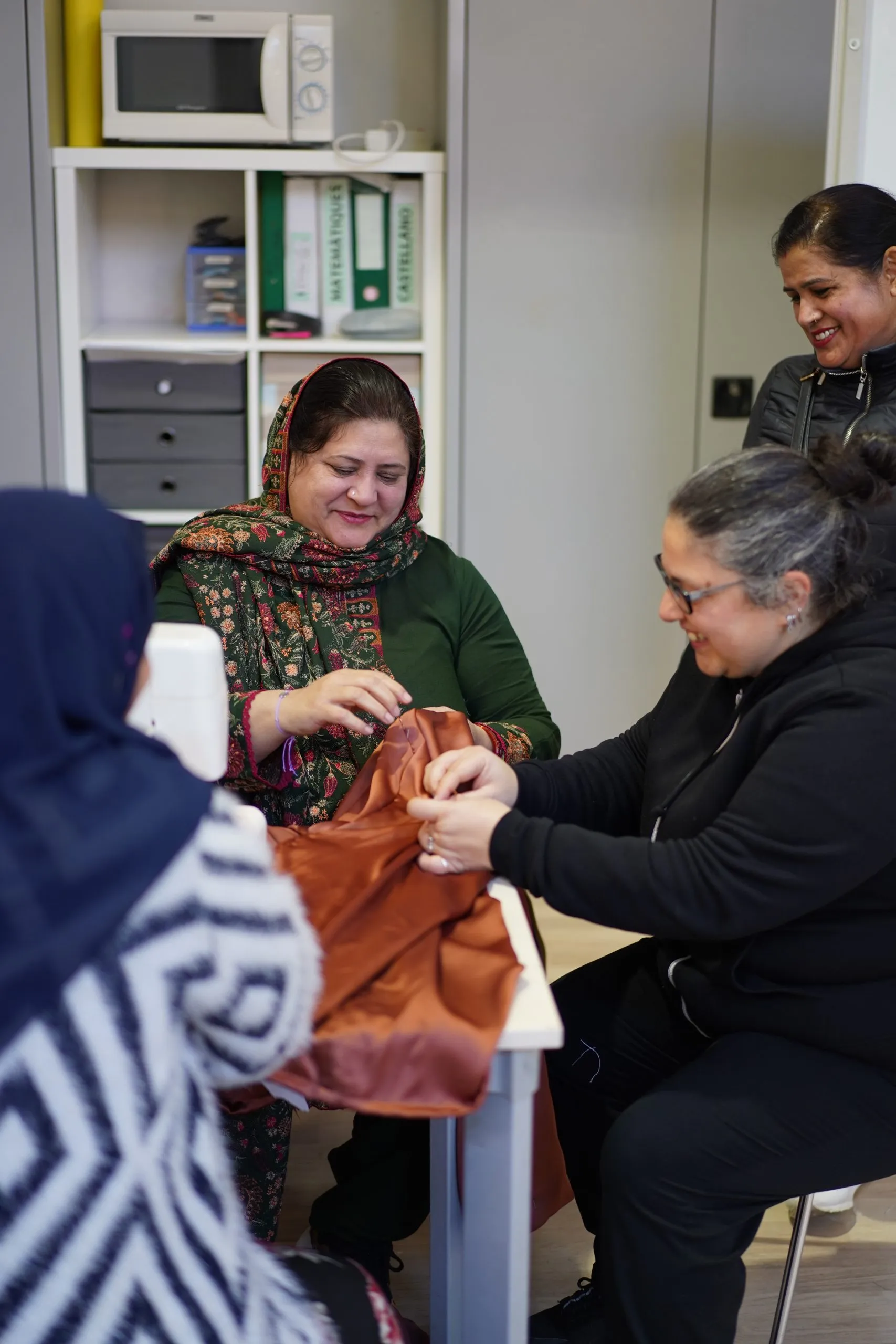 Dones aprenent a cosir i amb els somriures bonics i contents. Casal Familiar