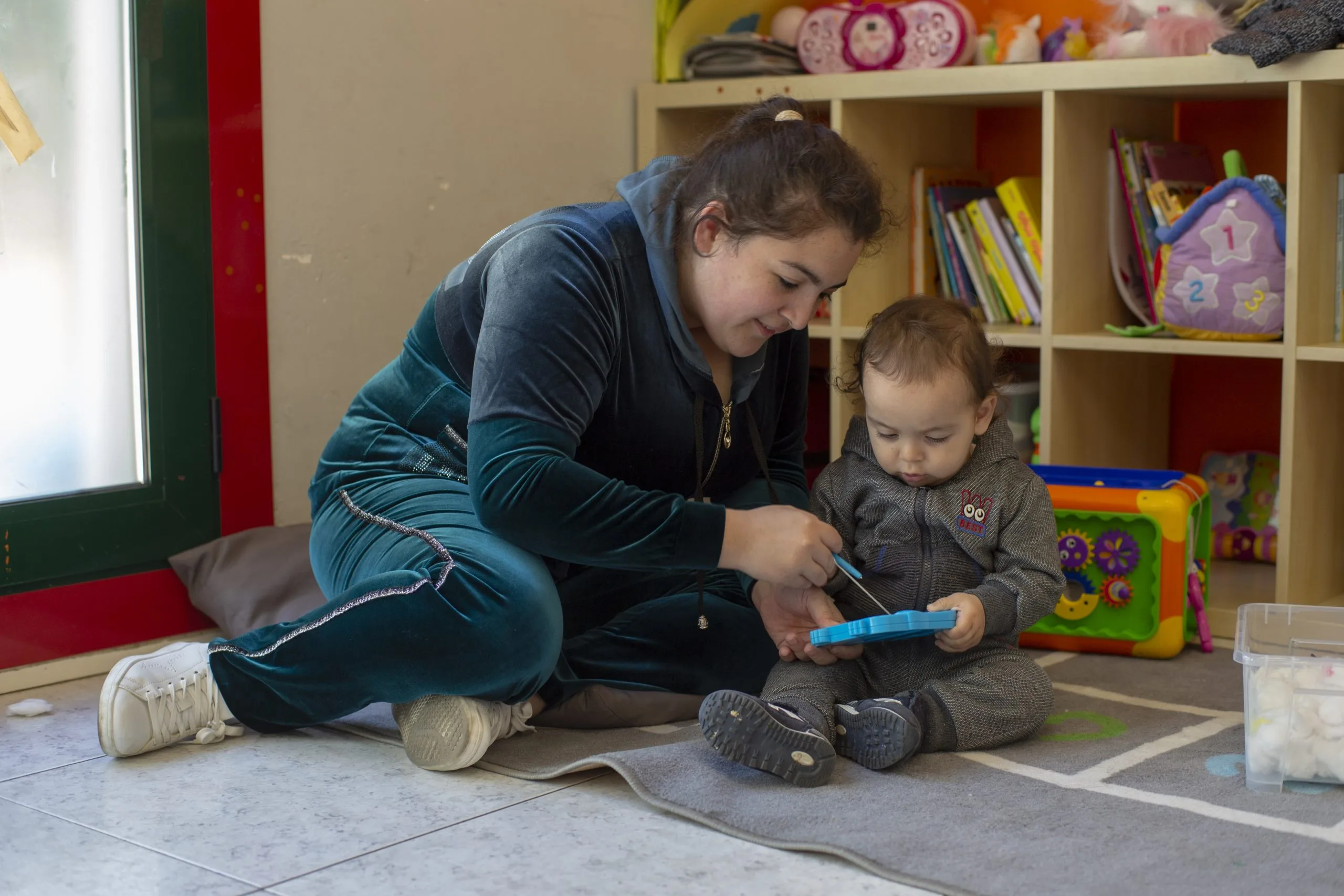 Una mare jugant amb el seu fill en un espai del Casal. Vincles