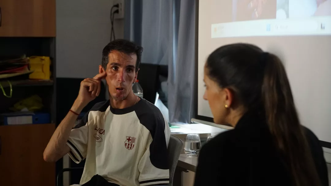 Àlex Roca parla i mira a la Mari Carme Maza, qui interpreta la llengua de signes.