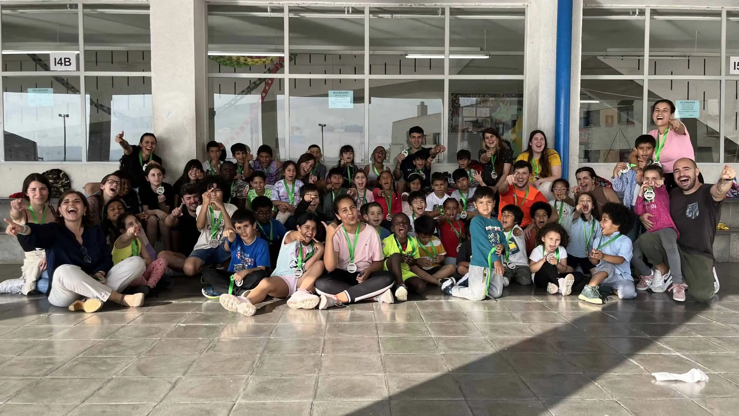 Nens i nenes posen a càmera amb la seva medalla.