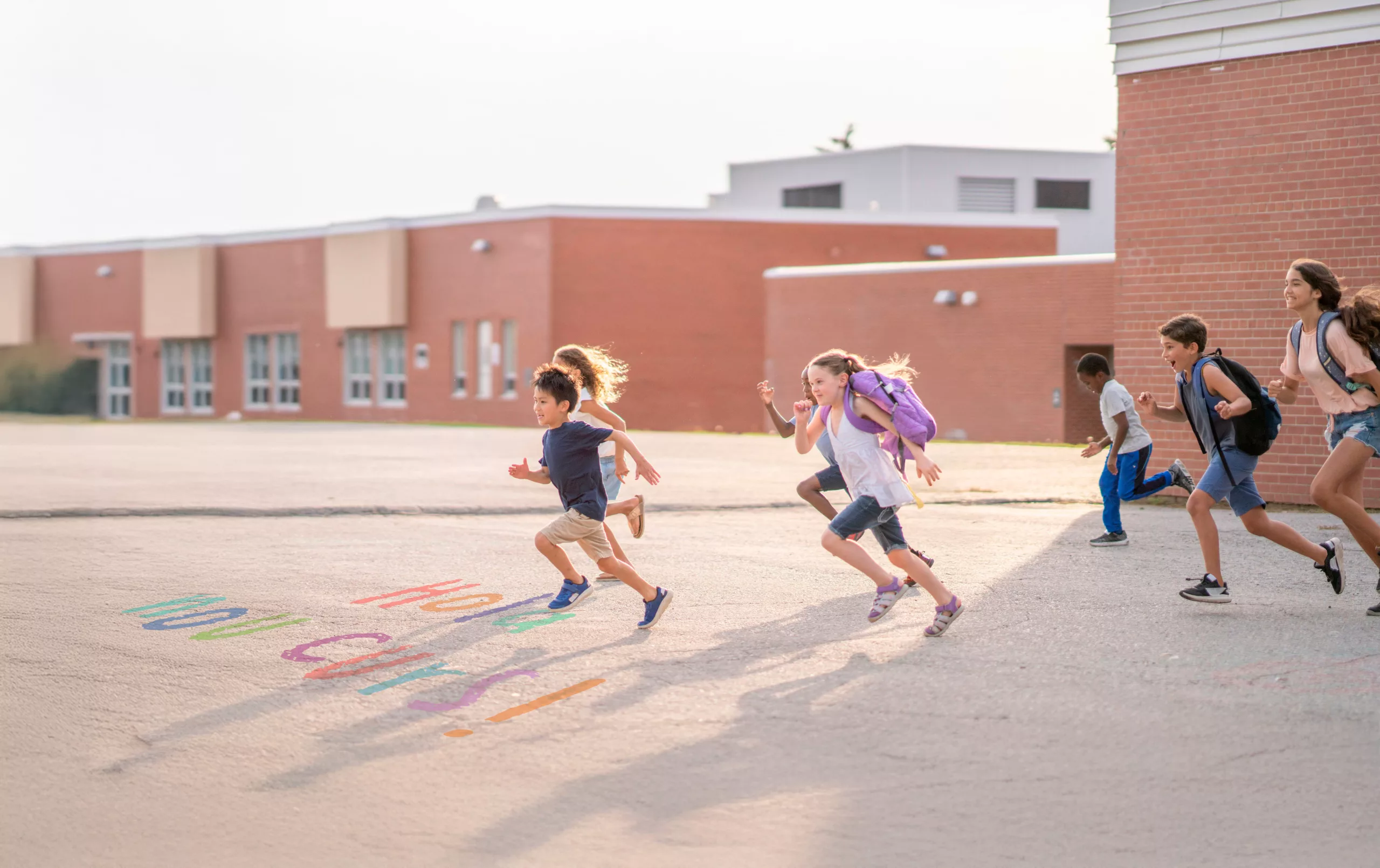 Nens i nenes en corrent amb les motxilles a l'esquena per a inici del curs.