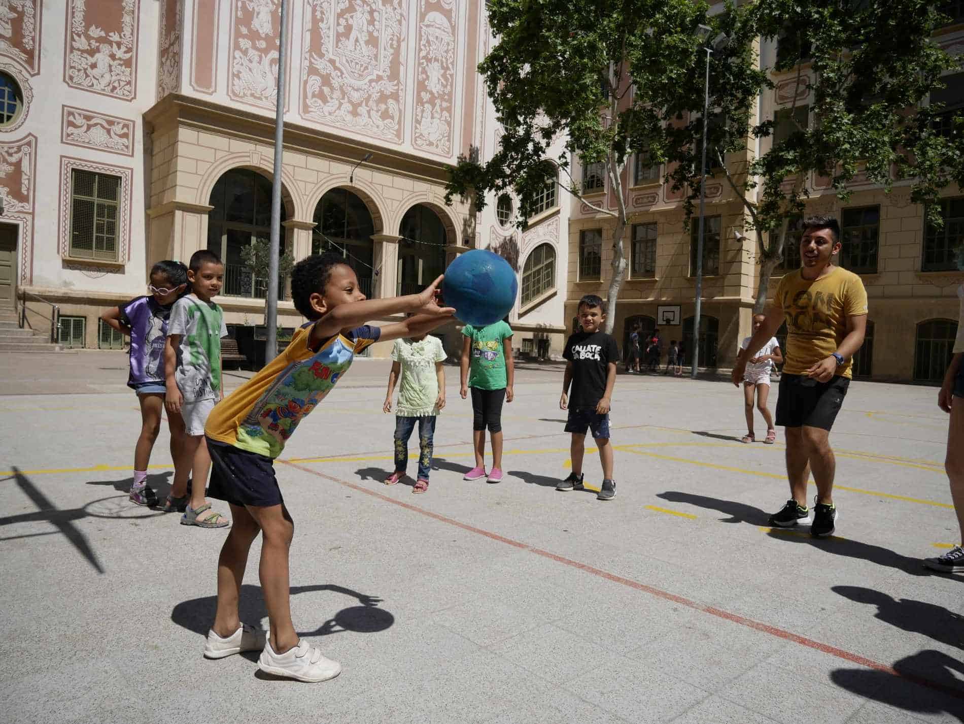 Nens jugant a pilota durant el casal d'estiu a l'escola Milà i Fontanals