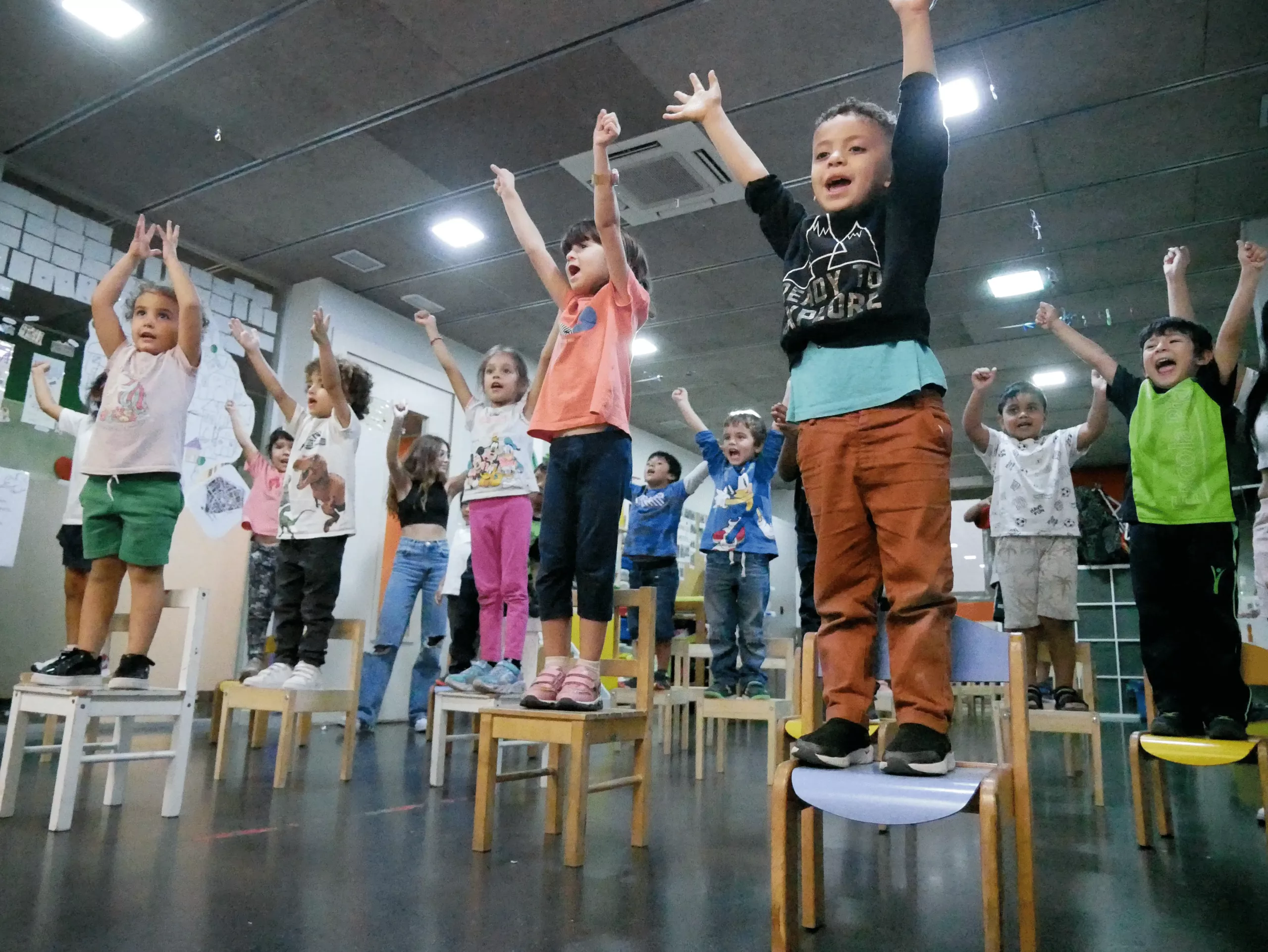 Nens ballant a dalt d'una cadira