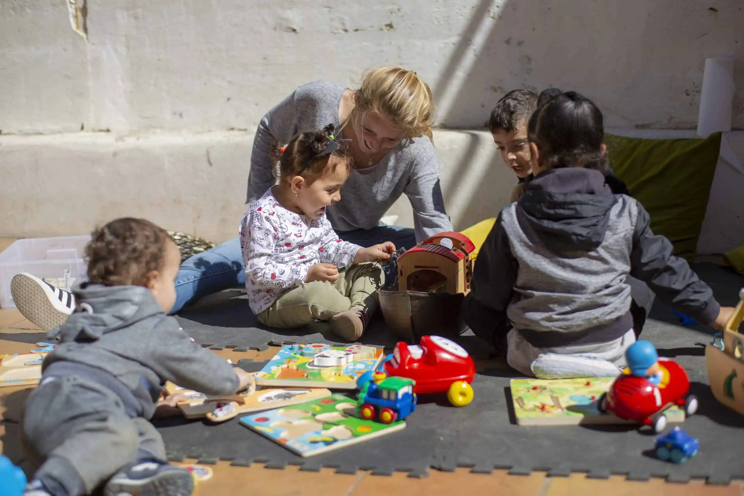 Imatge d'una noia jugant amb nens i nenes del Casal