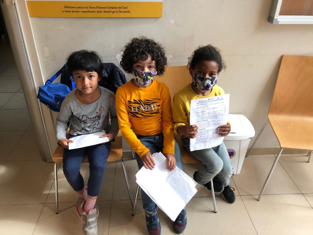 Tres infants amb els informes de la revisió d'"Et mirem als ulls"