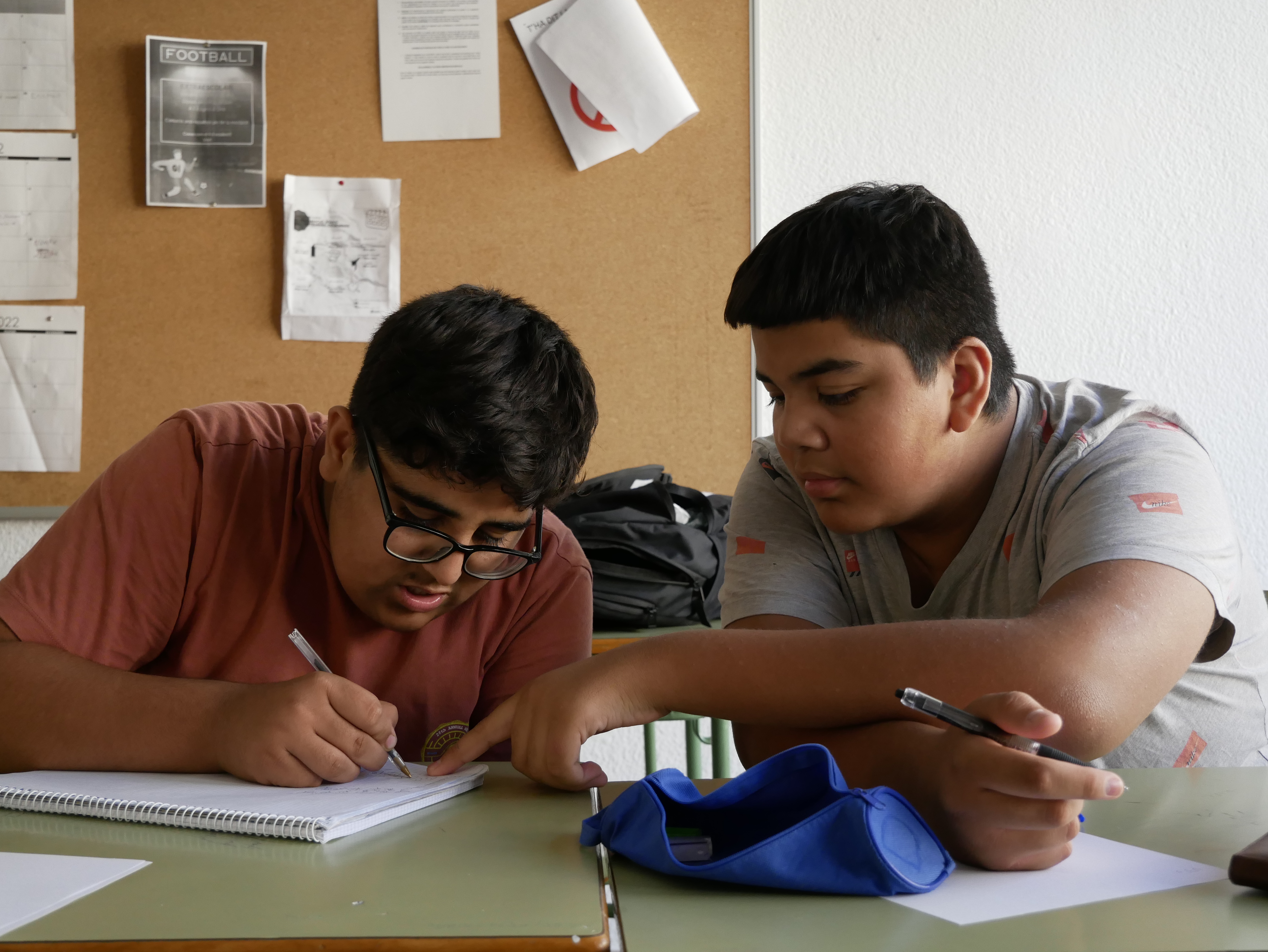 Dos nois fan els deures junts. 