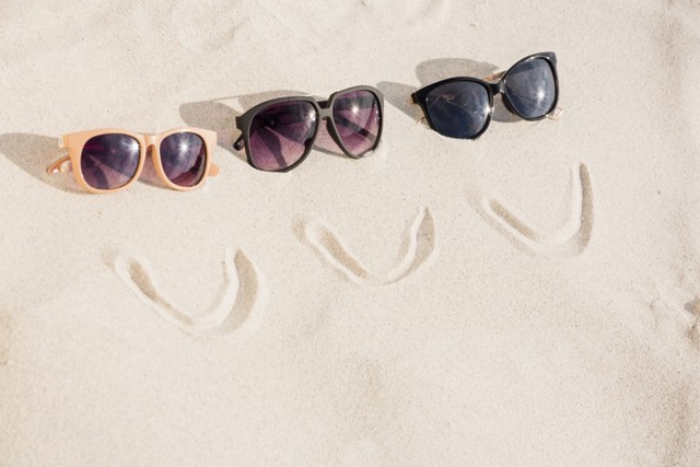 3 ulleres de sol a la sorra de la platja 