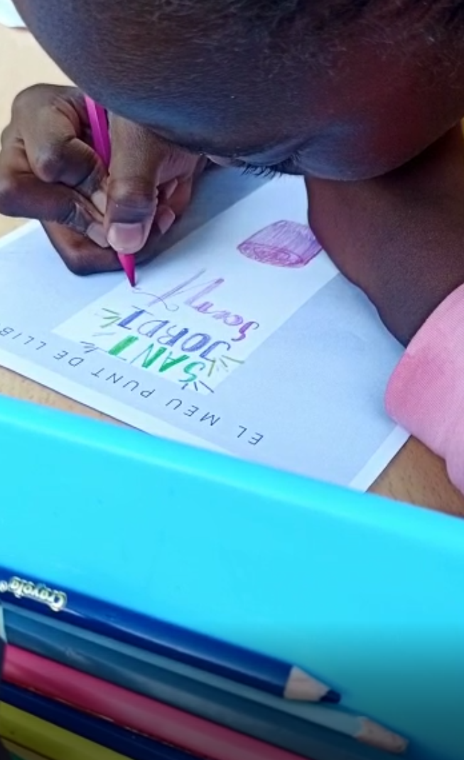 Nena dibuixa un punt de llibre. 