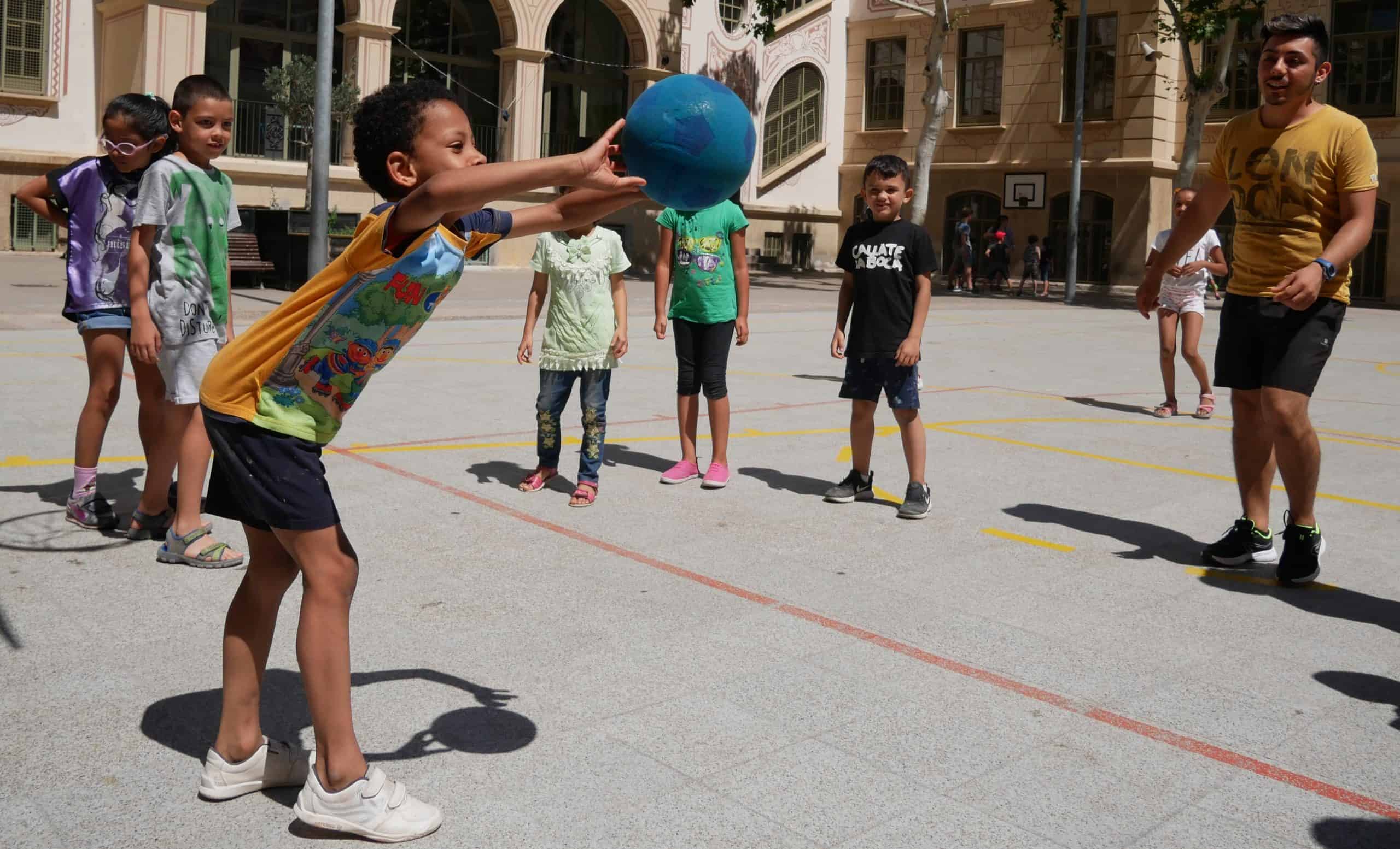 Nens i nenes jugant amb una pilota.