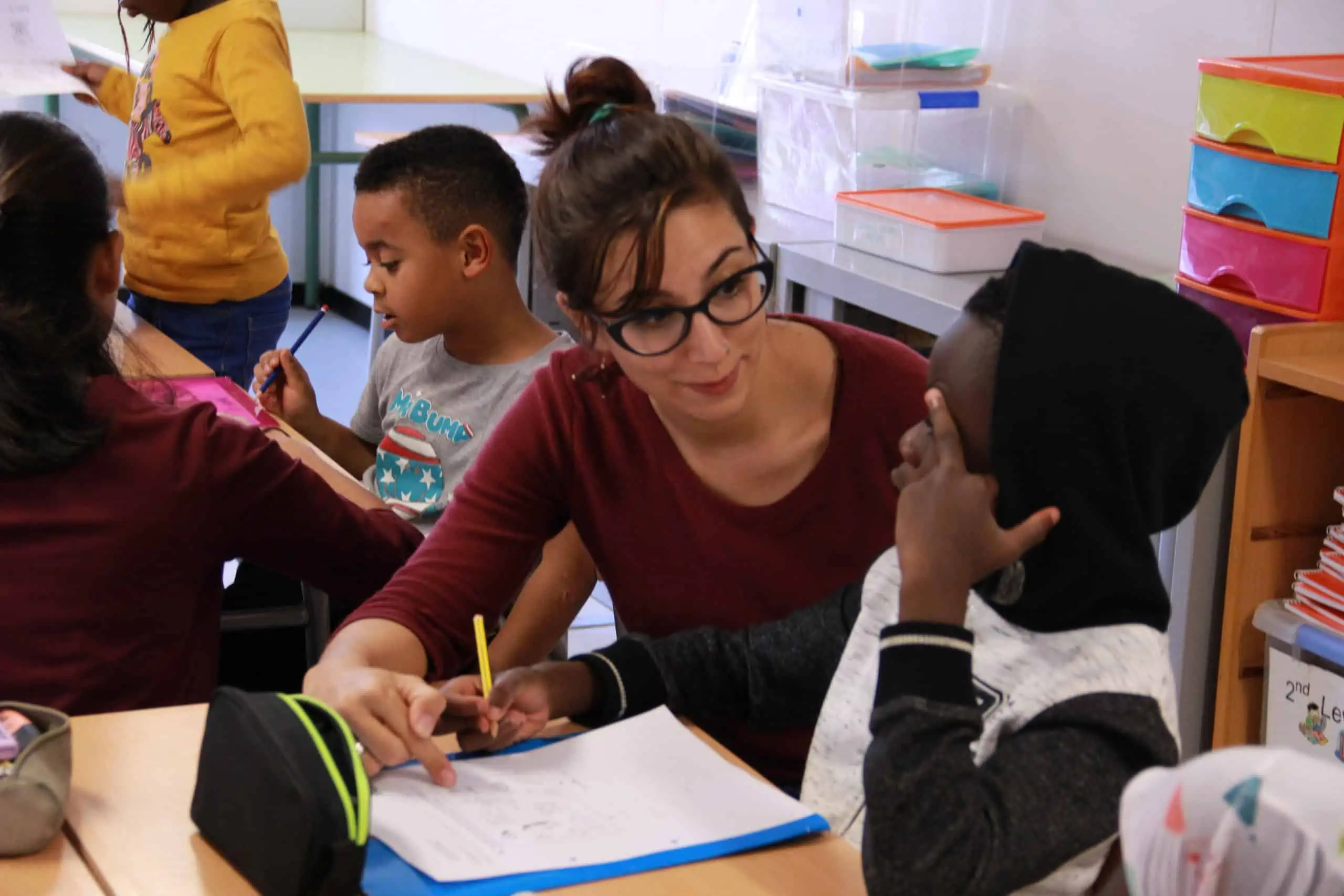 Una voluntaria ajuda a un nen a fer deures