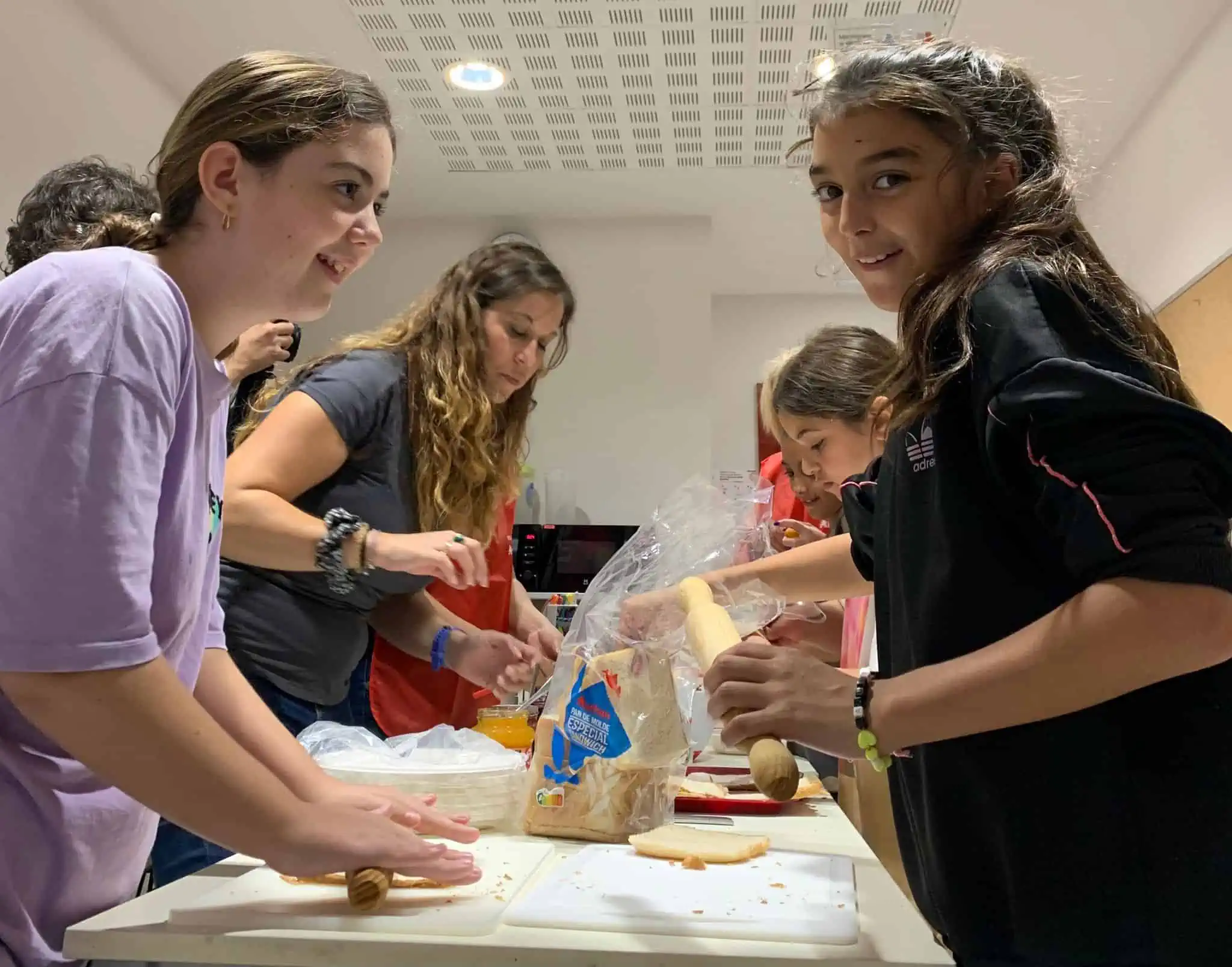 Noies cuinant al taller de "comer con sentido"